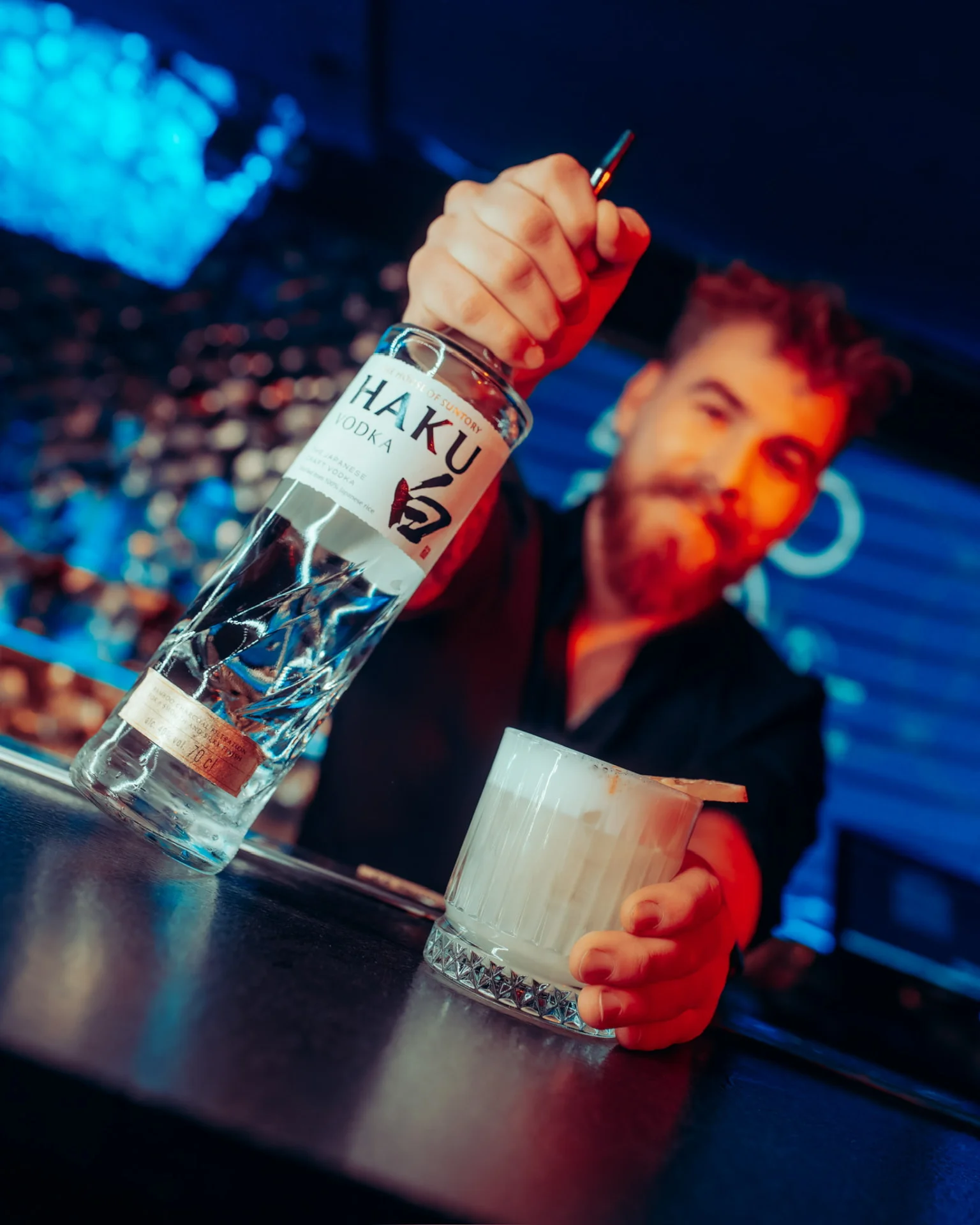 Barman z butelką wódki Haku