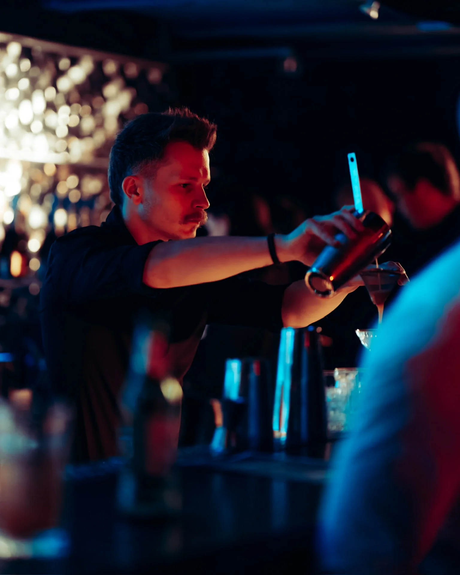Barman przelewa drinka z shakera